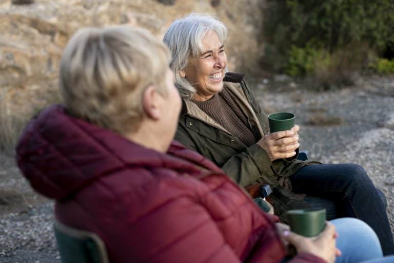 two older female friends enjoying hike together nature